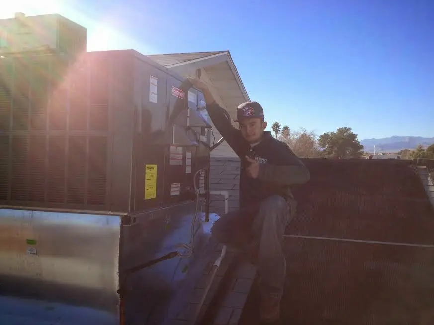 HVAC technician performing Air Duct Cleaning on a rooftop unit in Hamburg